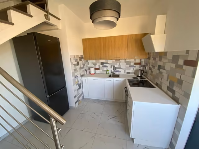 Angolo cottura con piano di lavoro e pensili dell'appartamento di Residenze Valle Caterina