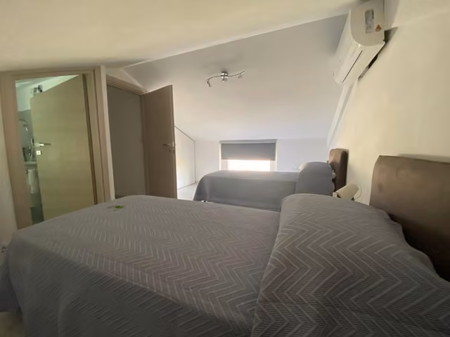 Camera con letto matrimoniale e arredi chiari