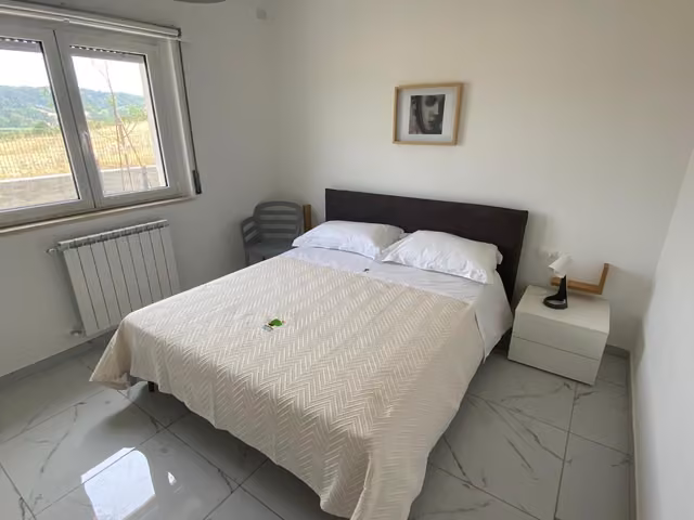 Camera matrimoniale con lenzuola bianche