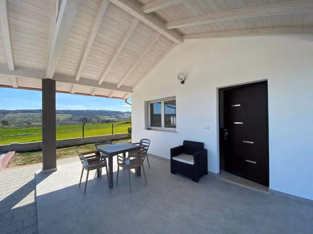 Patio con tavolo e sedie e vista sulle colline di Torino di Sangro, Residenze Valle Caterina