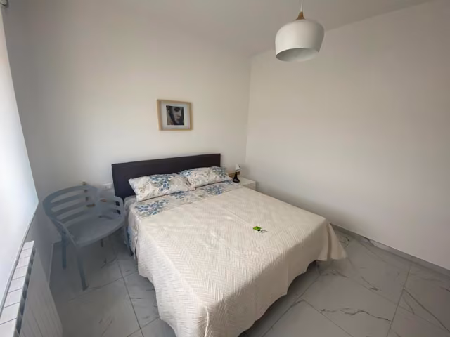 Camera da letto con letto e sedia blu di Residenze Valle Caterina, Costa dei Trabocchi
